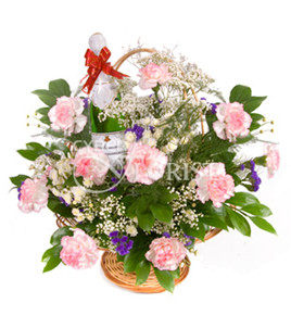 Inspiration. Subtle red and white carnations with baby's breath and greens are arranged in a round basket with a bottle of sparkling wine. A wonderful present for any holiday.
